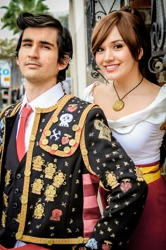 a man and woman dressed in costumes standing next to each other