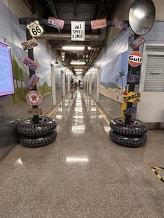 an empty hallway with several signs and tires on the floor