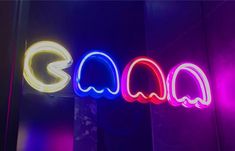 a neon sign that is on the side of a wall in front of a mirror