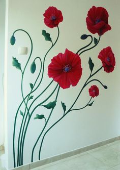 red flowers painted on the side of a white wall with green leaves and stem stems
