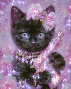 a black kitten wearing a pink bow and holding a crystal cross in its paws with glitters all around it