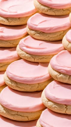 pink frosted cookies are stacked on top of each other