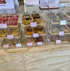 a display case filled with lots of different types of doughnuts and pastries