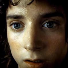 a close up of a person's face with freckled hair and blue eyes