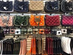 many different purses are on display in a store