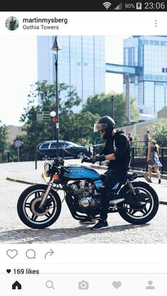 a man riding on the back of a blue motorcycle