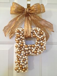 the letter p is made out of pearls and gold ribbon with a bow on it
