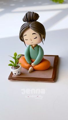 a small figurine sitting on top of a table next to a potted plant