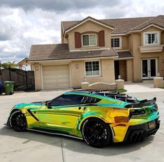a yellow and green sports car parked in front of a house on a cloudy day