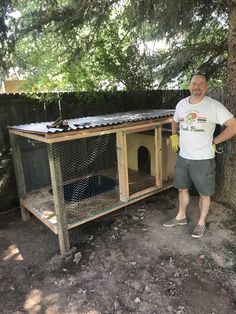 a man standing next to a chicken coop