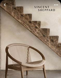a wooden chair sitting in front of a stair case