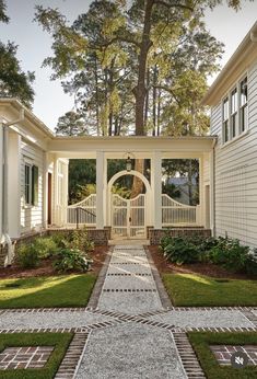 a white house with a walkway leading to the front door