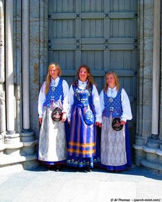 three women dressed in traditional clothing standing next to each other