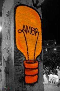 an orange lightbulb with the word roma written on it, in front of a crowd