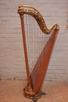 a large wooden harp sitting in front of a white brick wall