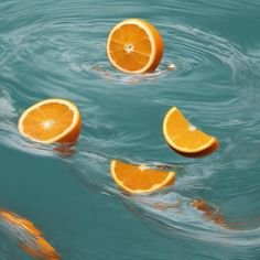 three oranges floating in the water with their tops upside down and one cut open