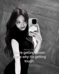 a woman taking a selfie with her cell phone while wearing a black dress and high heels