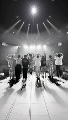 a group of people standing on top of a stage with their arms in the air