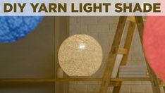 the light shade is made from yarn and has been placed on top of a ladder