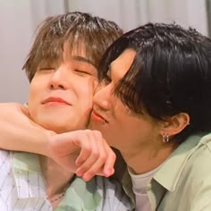 two people are kissing each other while one person has his arm around the other's shoulder