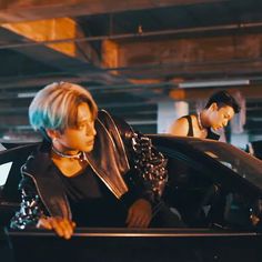 two women sitting in the back of a black car