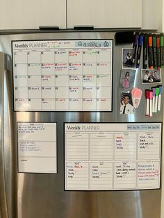 a stainless steel refrigerator with magnets and calendars on the door, in front of a white wall