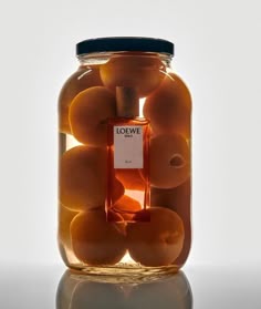 a jar filled with oranges sitting on top of a table