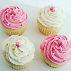 four cupcakes with white and pink frosting