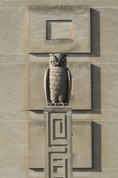an owl statue on the side of a building