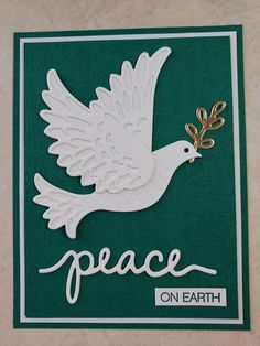 a peace card with a white dove holding a golden object in it's beak