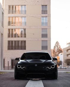a black car parked in front of a tall building