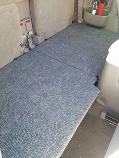 the interior of a car with blue carpet and gray seat covers on it's back