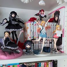 some anime figurines sitting on top of bookshelves in a room full of books