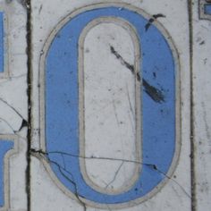 an old blue and white sign with the letter o painted on it's side