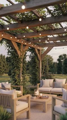 an outdoor living area with couches, tables and lights on the pergoline
