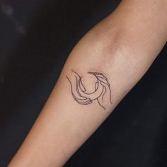 a woman's arm with a small tattoo on it