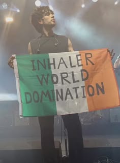 a man holding a sign that says inhaler world dominion