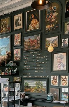 there is a wall with many pictures on it and a lamp hanging from the ceiling