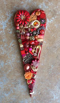 a heart - shaped object with many different items on it's sides, sitting on a stone surface