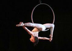 a man is doing aerial acrobatics on a hoop