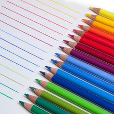 many colored pencils lined up on top of each other