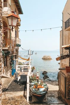 a boat is parked on the side of an alley way next to some buildings and water