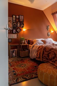 a bed room with a neatly made bed and lots of pictures on the wall above it