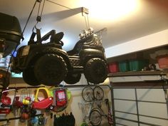 two atvs hanging from the ceiling in a garage with tools and other items on it
