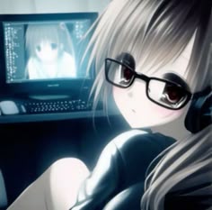 a woman with glasses and headphones sitting in front of a computer