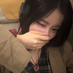a woman with headphones covering her mouth
