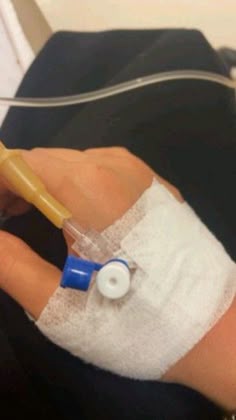 a hand with an iv attached to it and bandaged around the wrist is shown