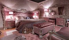 a fancy bedroom with pink walls and furniture