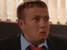 a man in a suit and tie looking at the camera with an angry look on his face