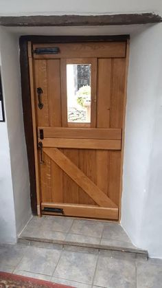 a wooden door that is open on the side of a house with tile flooring
